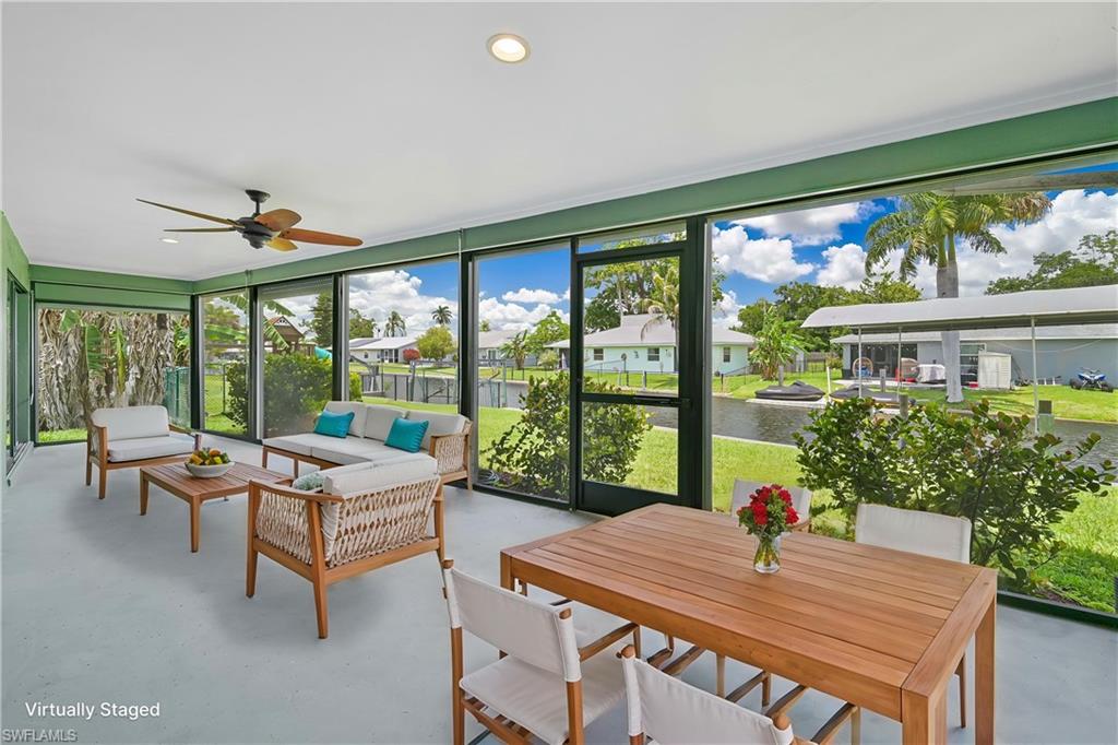 Spacious screened lanai featuring a ceiling fan, recessed lighting, and expansive views of the adjacent canal