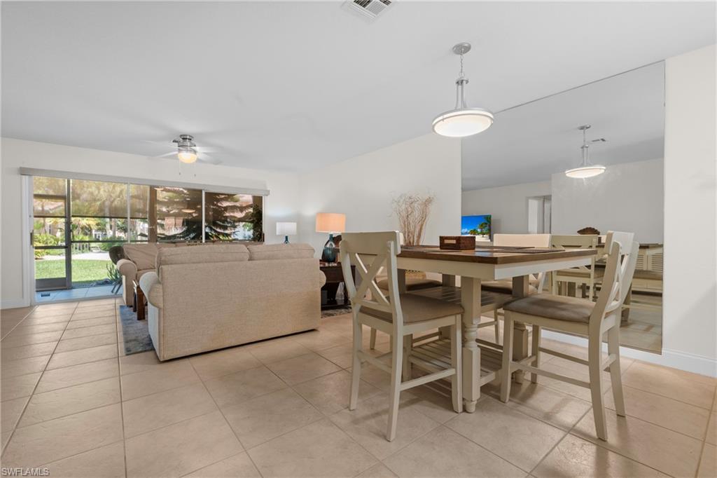 Open concept dining area with pendant lighting and full-height mirrored wall