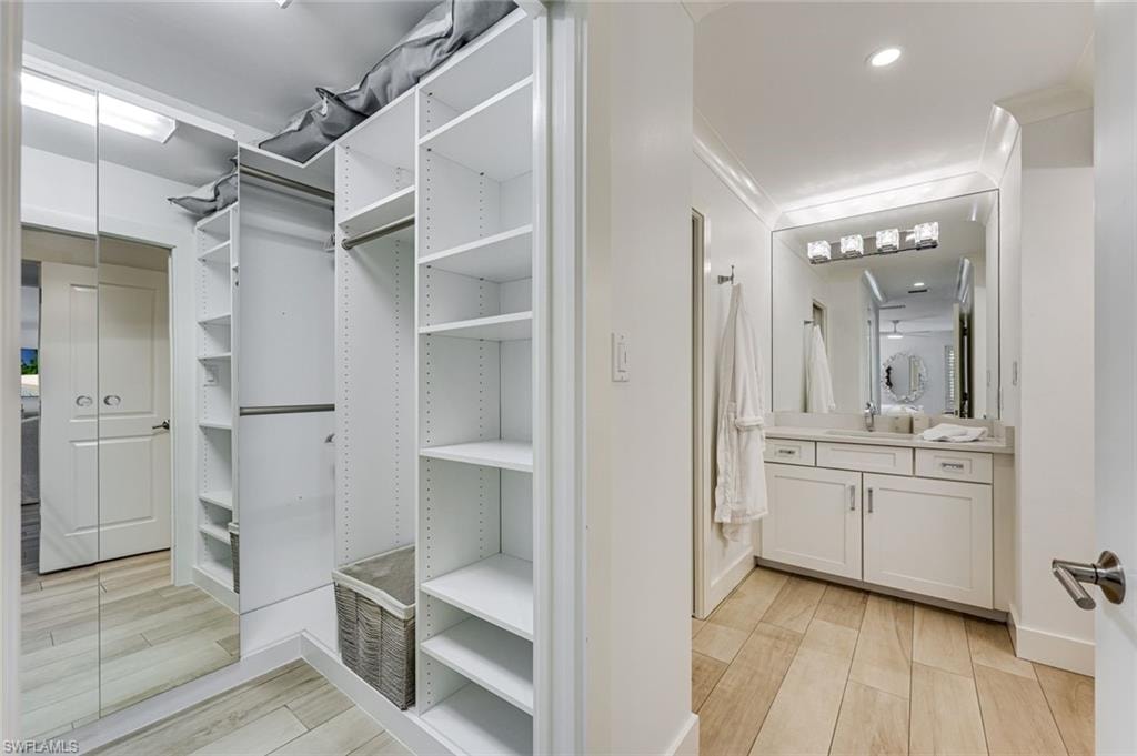 Primary walk in closet with custom cabinetry