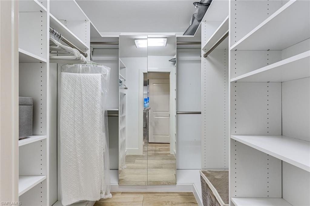 Primary walk in closet with custom cabinetry