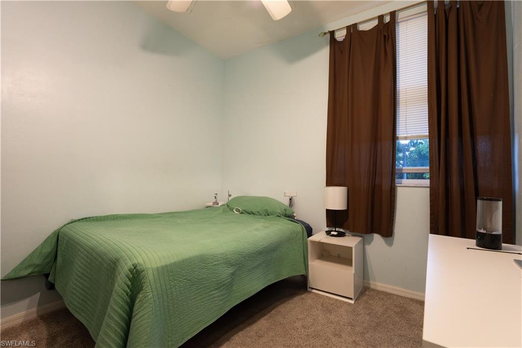 Carpeted bedroom featuring ceiling fan