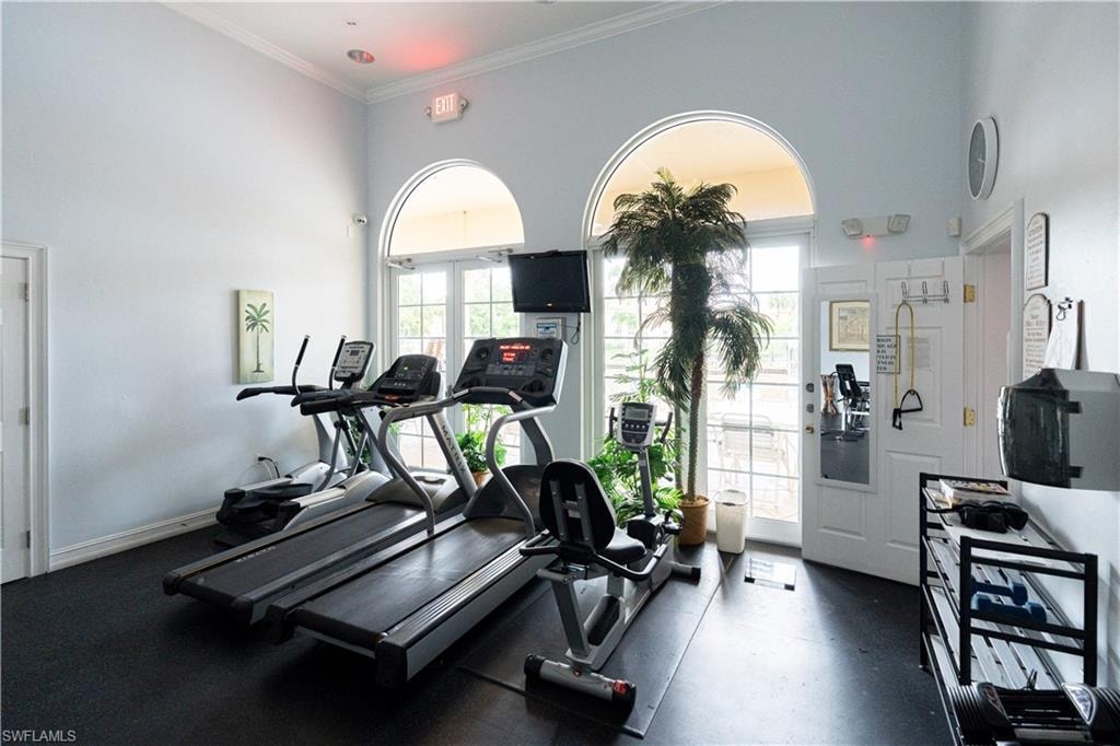 Workout area with a high ceiling and ornamental molding