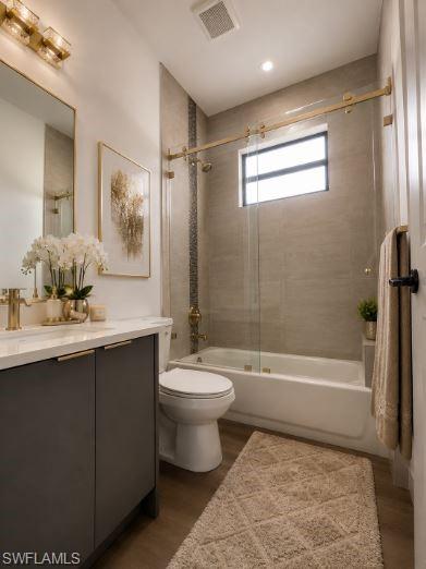 Full bathroom featuring a dark gray vanity with a light countertop, a built-in tub with a sliding glass door, and brass-finish fixtures