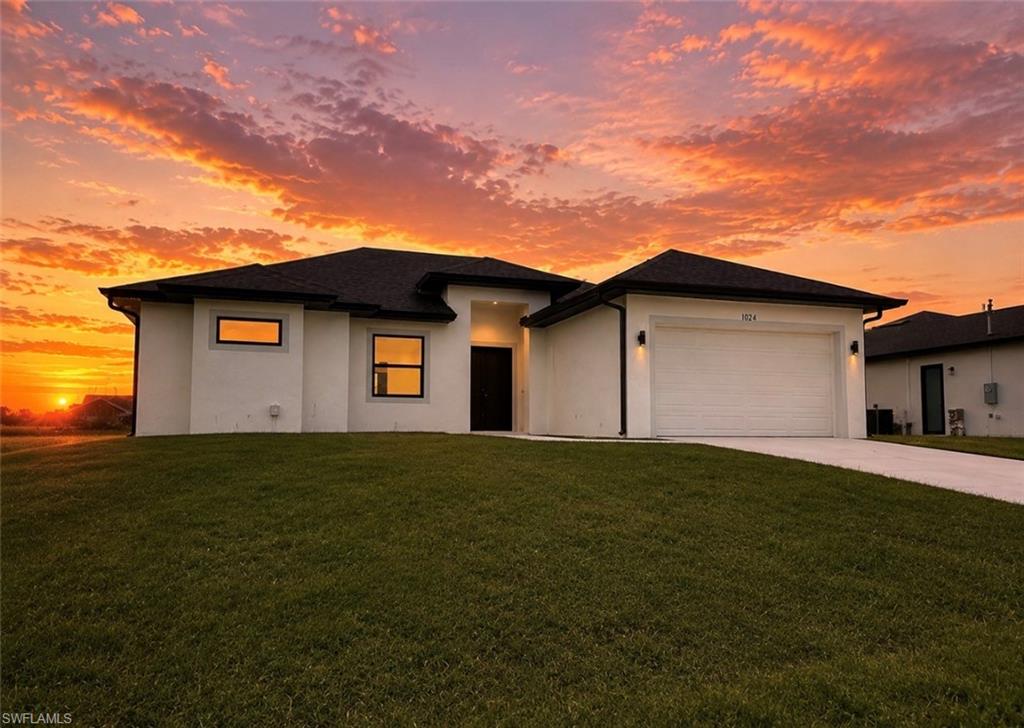 Contemporary single-story residence featuring a white stucco exterior and dark framed windows