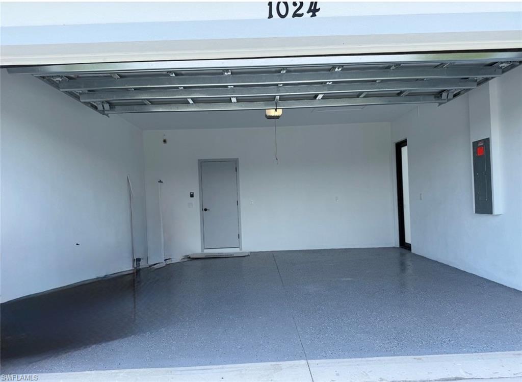 Two-car garage featuring a speckled epoxy floor and side door
