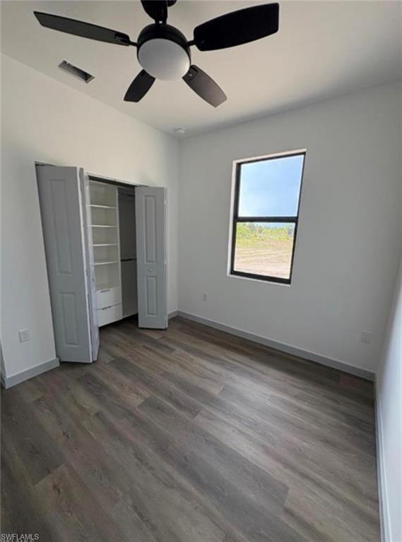 Room featuring wood-finish flooring, a contemporary ceiling fan with integrated lighting, and a window with dark framing