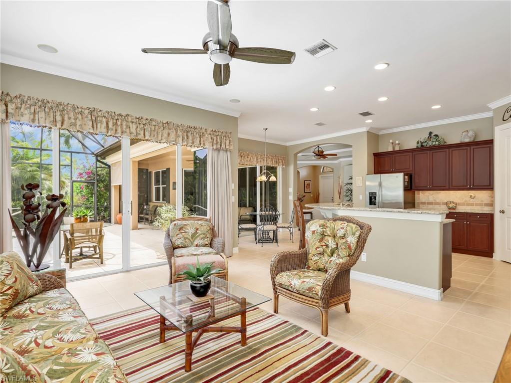 Family Room with Crown Molding, Ceiling Fan, with Sliders Leading to the Screened-In Lanai with a Pool View, Kitchen, and Eat-In Kitchen with Sliders also Leading to the Screened-In Lanai with a Pool View