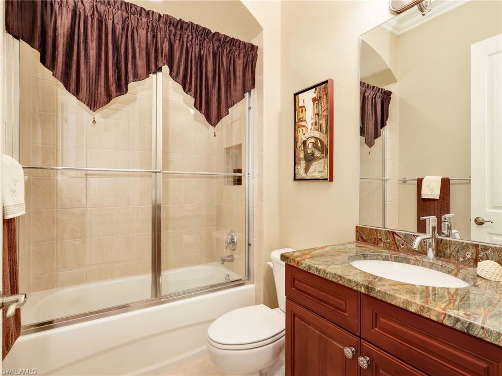 Second Bathroom with Tile Tub Shower Combo with Glass Sliding Doors, and Natural Stone Vanity