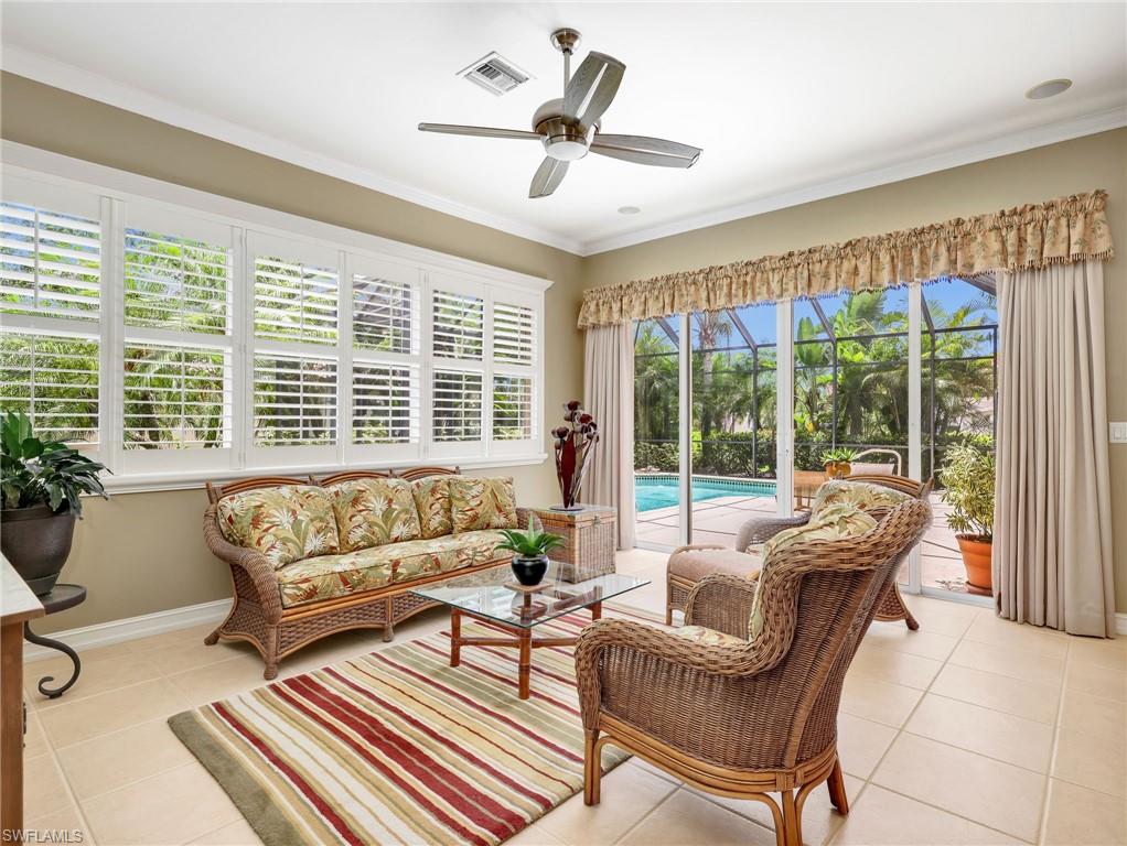 Family Room with Plantation Shutters, Ceiling Fan, & Sliders Leading to the Screened-In Lanai with a Pool View