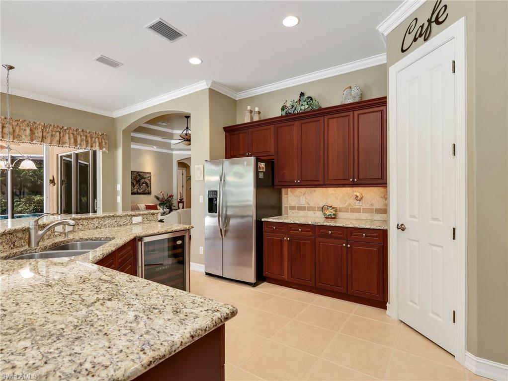 Kitchen with 42" Cabinetry, Crown Molding, Stainless Steel Appliances, Wine Fridge, Granite Countertops, Tile Backsplash, & Pantry