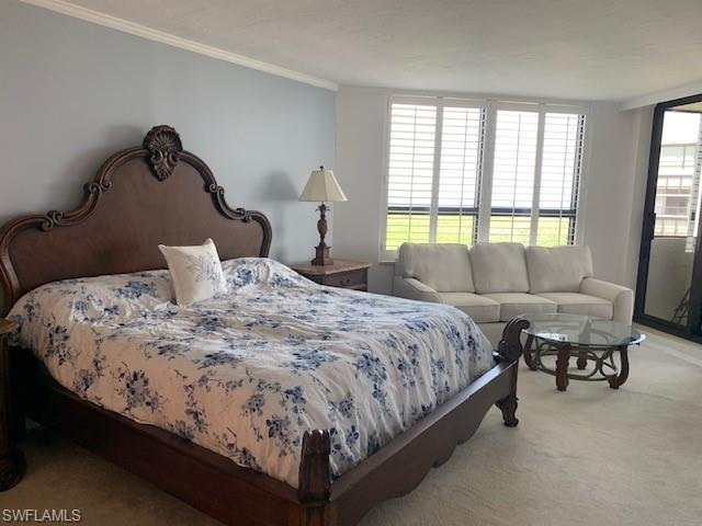 Bedroom featuring ornamental molding, multiple windows, and light colored carpet