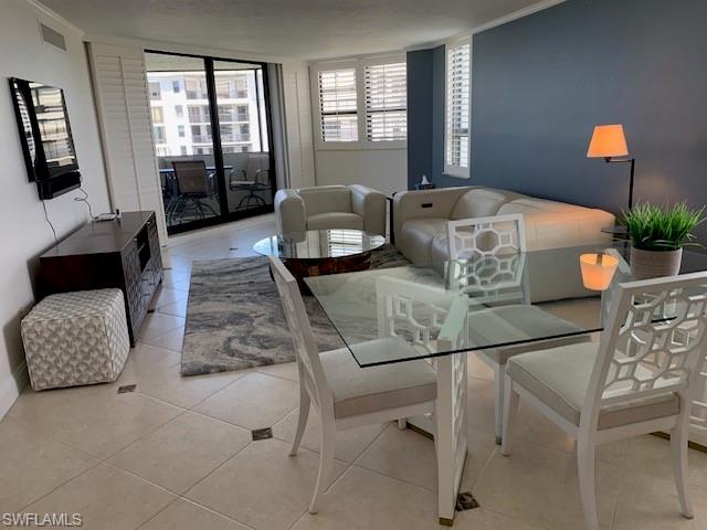 Tiled dining room featuring ornamental molding