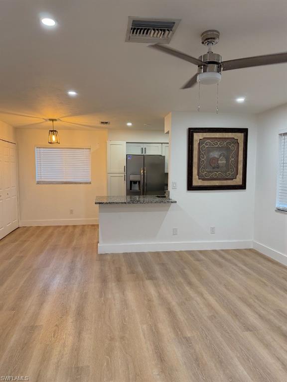 Open-concept living area featuring wood-finish flooring, recessed lighting, and a ceiling fan