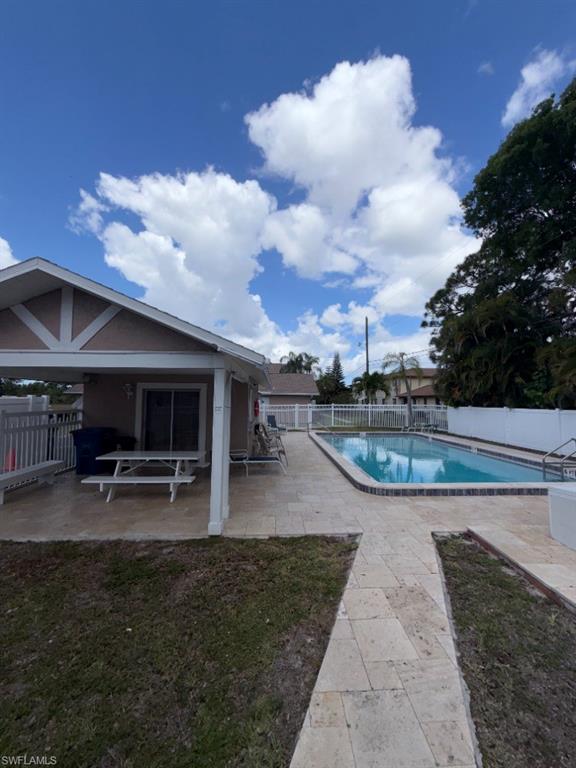 Rectangular swimming pool with a tile border and adjacent paver patio