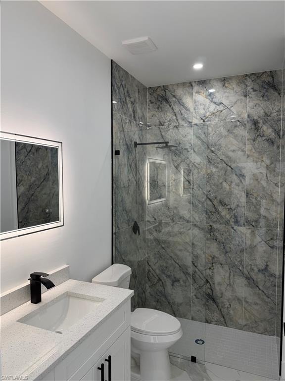 Contemporary bathroom featuring a spacious walk-in shower with large-format marbled tile, a frameless glass enclosure, a matte black rainfall shower head, and a built-in shower niche