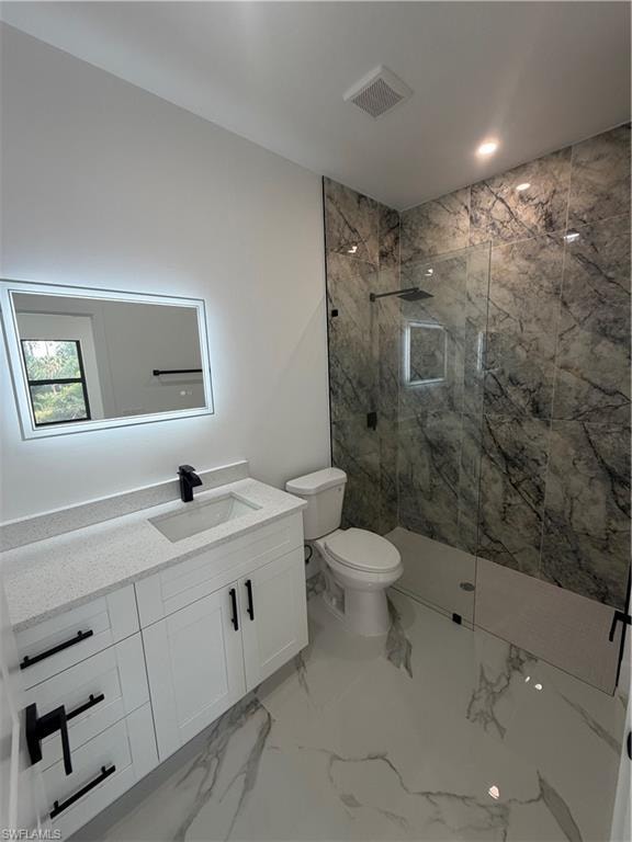 Modern bathroom featuring a glass-enclosed shower with dark marble-style wall tiling and a built-in niche