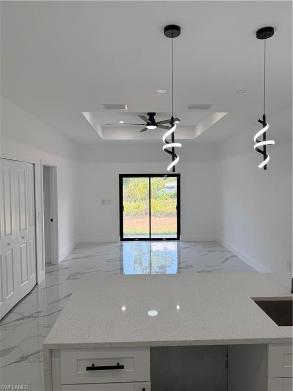 Open-concept interior featuring bright white walls, large format tile flooring, and a sliding glass door