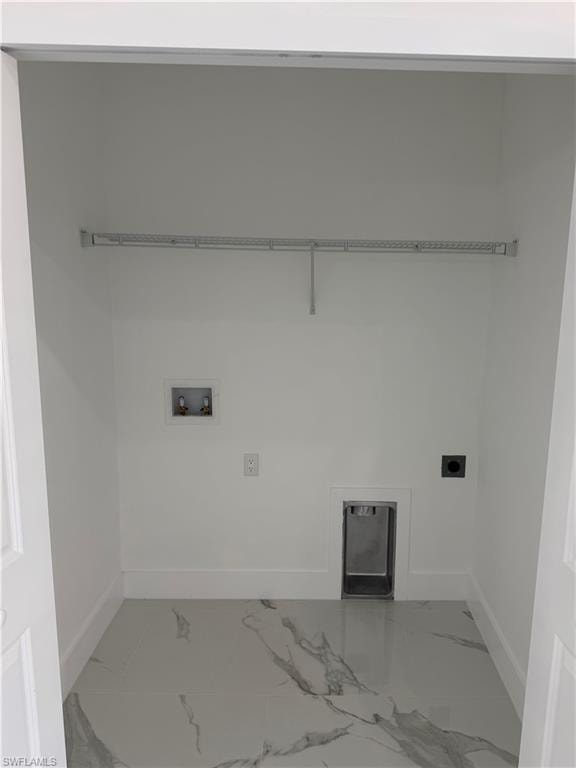 Utility room featuring a wire shelving unit, dedicated washer and dryer hookups, and white and gray marble-look flooring