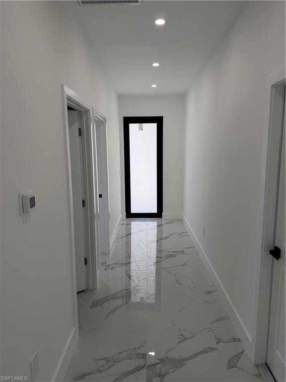 Hallway with polished tile flooring, recessed ceiling lighting, crisp white walls, and contemporary black door frames
