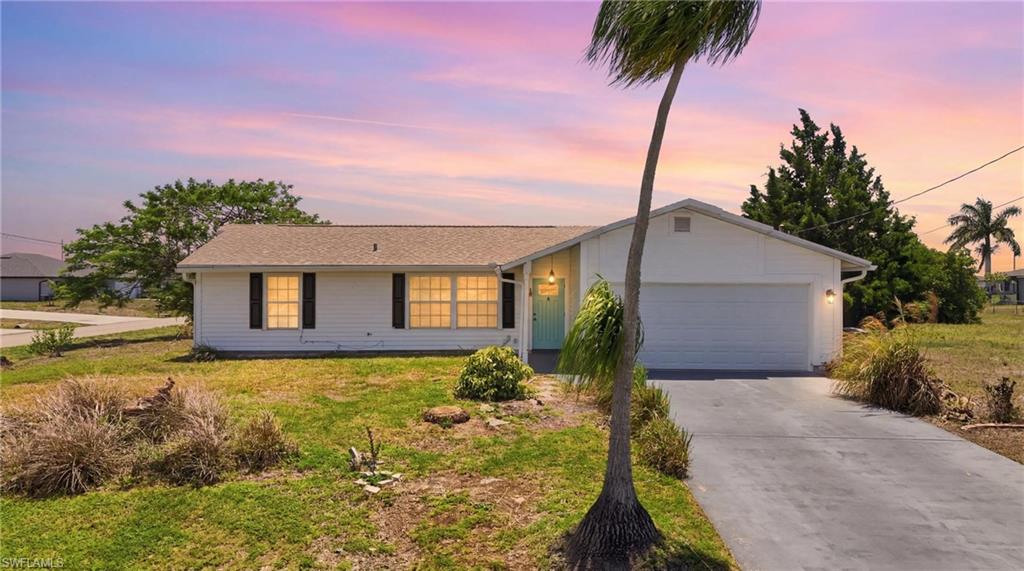 Single-story residence featuring a white exterior, attached garage, and a concrete driveway