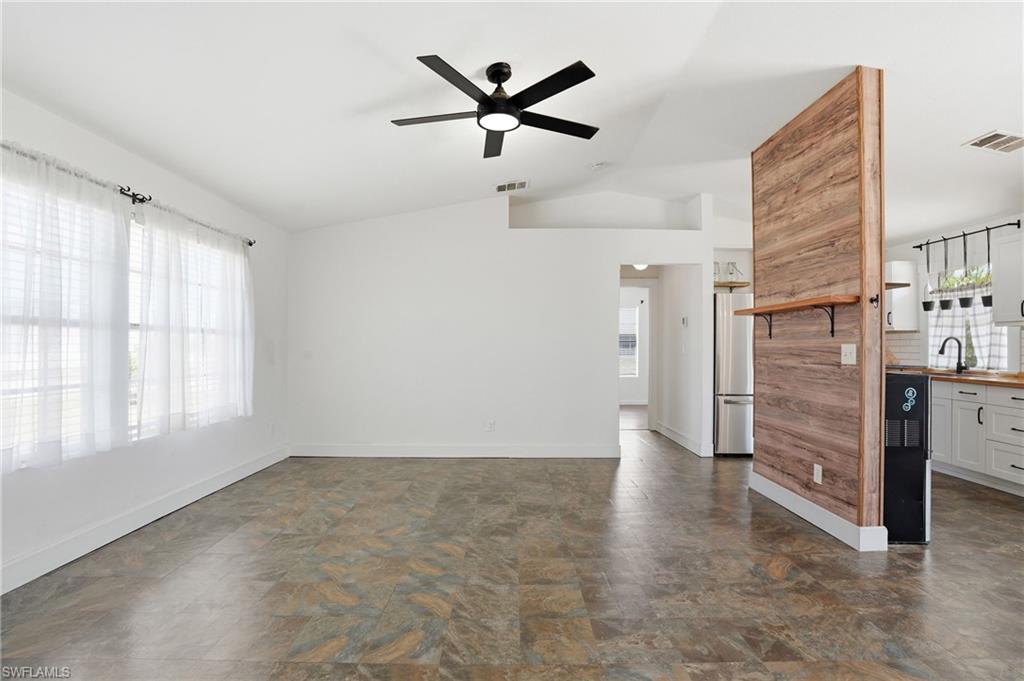 Expansive living area with vaulted ceilings and a ceiling fan