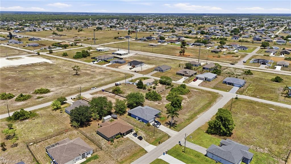 Aerial perspective showcasing a residential area with single-family homes and undeveloped land parcels