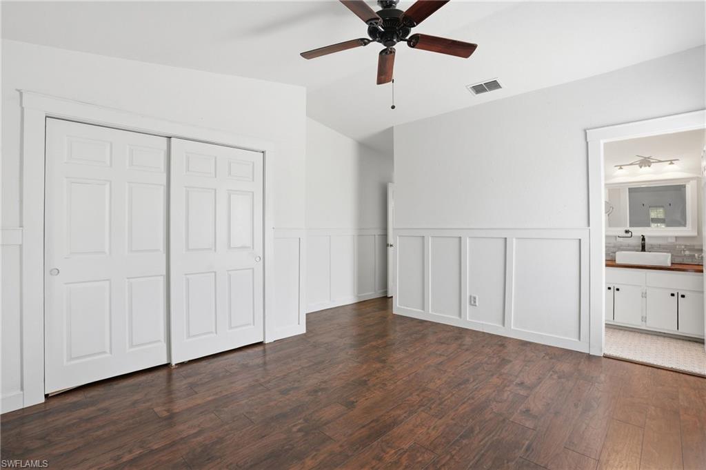Wood-finish flooring throughout, complemented by white wainscoting and a ceiling fan