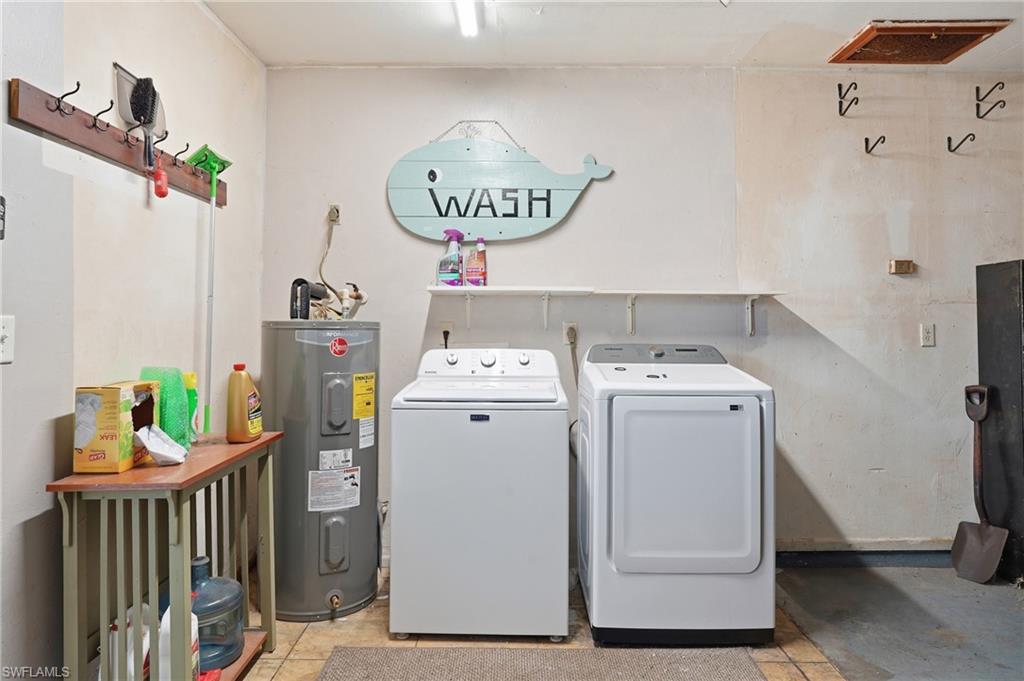 Dedicated laundry area featuring a water heater, ceramic tile flooring, and overhead lighting