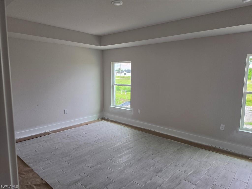 Recessed ceiling with tray detailing, light gray wall paint, and two windows