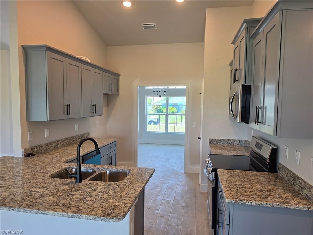 Kitchen featuring light gray cabinetry, granite countertops, and stainless steel appliances