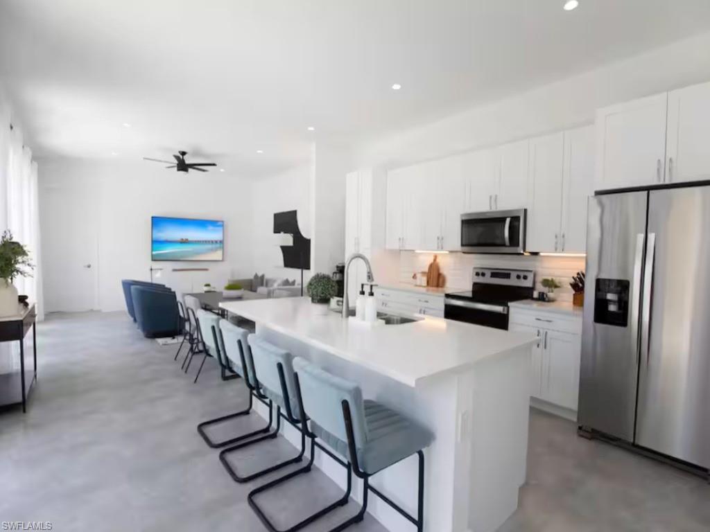 Open-concept living space with a kitchen island featuring a white countertop