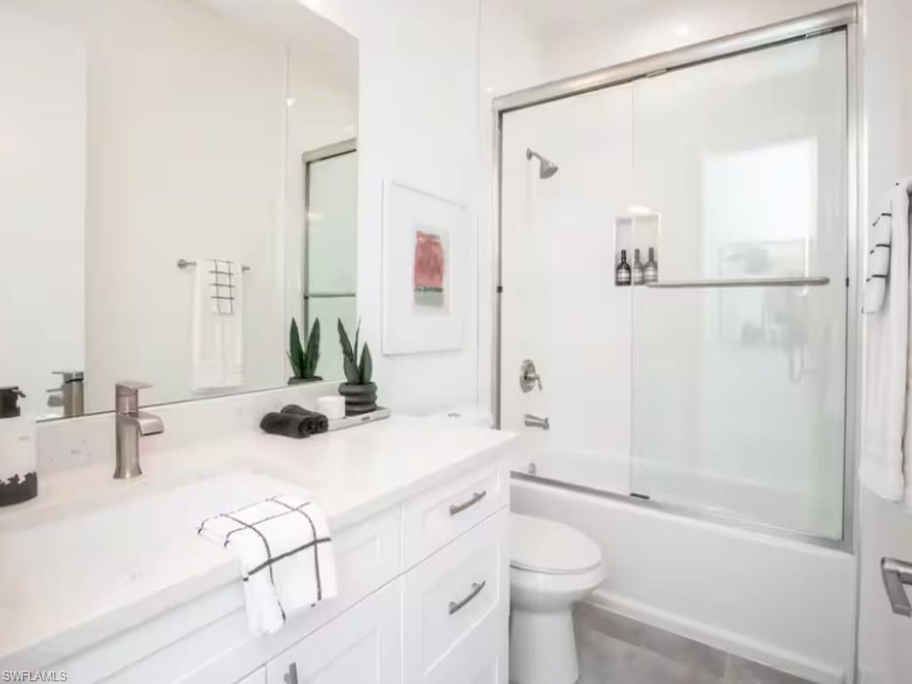 Bathroom featuring a white vanity with a single sink, brushed nickel faucet, and white countertop