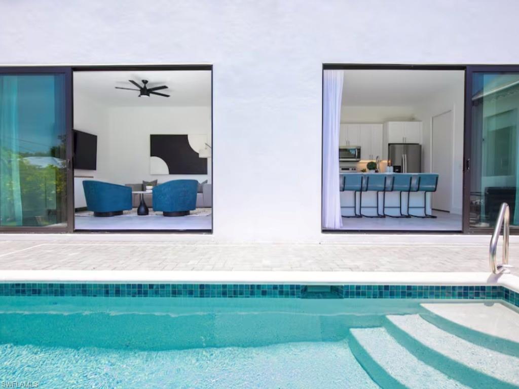 Outdoor swimming pool featuring integrated steps and mosaic tile detailing