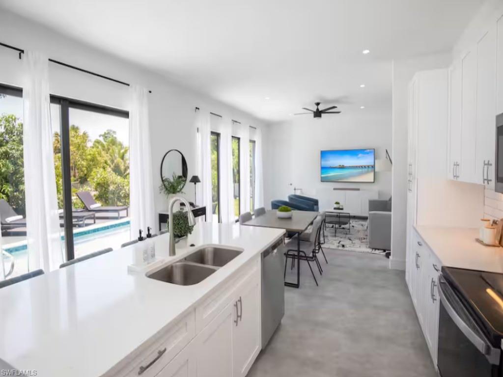 Open-concept kitchen with living space with large format tile flooring and abundant natural light