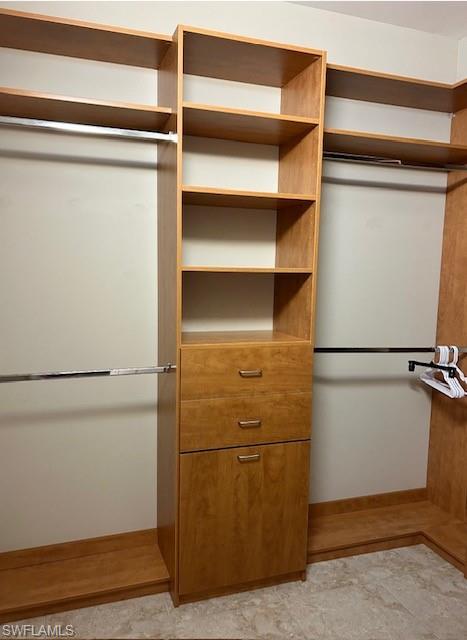 Walk in closet with light tile floors