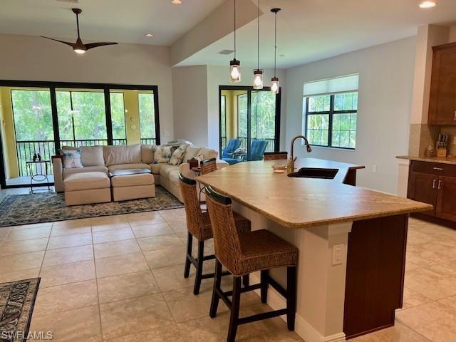 Tiled dining area featuring sink and ceiling fan