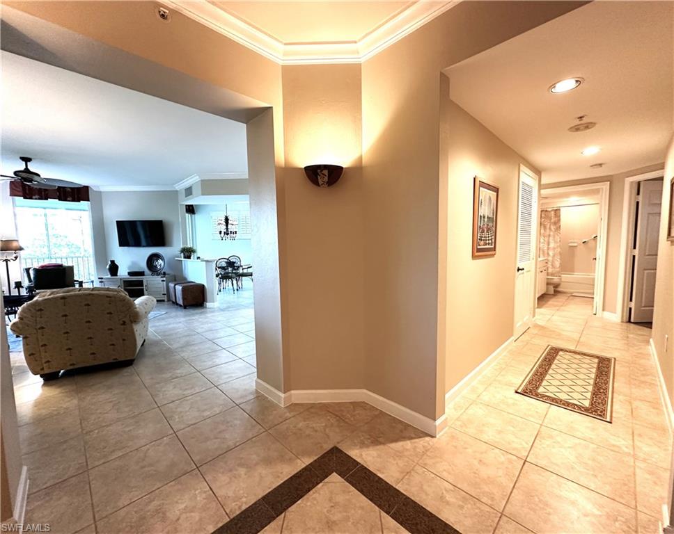 Hall featuring crown molding and light tile flooring