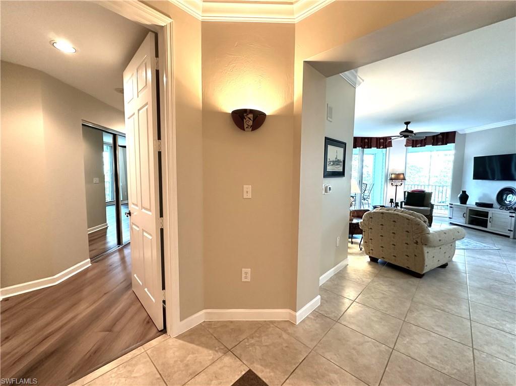 Hall with tile floors and ornamental molding