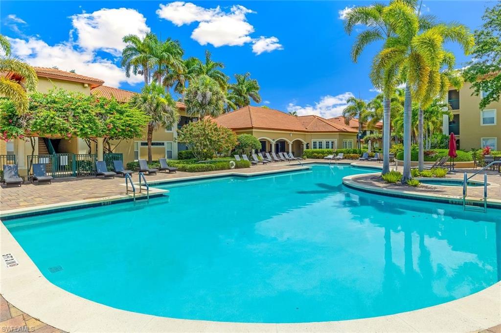 Expansive resort-style community swimming pool featuring integrated steps and a surrounding paver deck