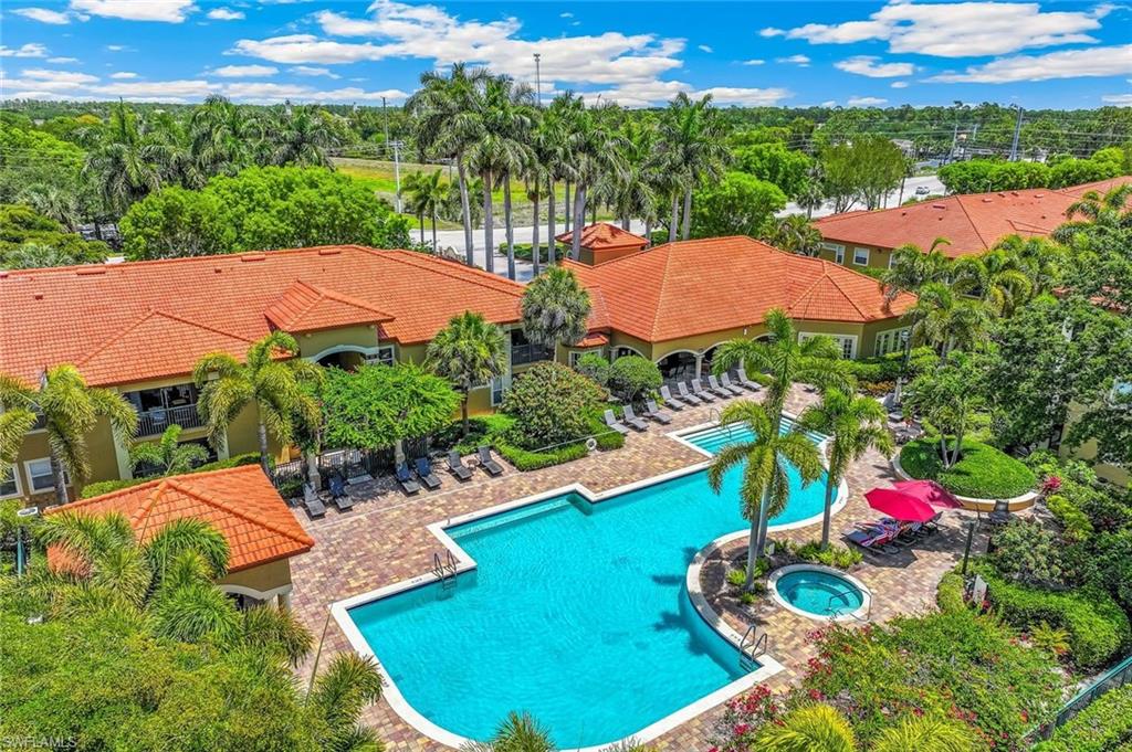 Community recreational area featuring a large, freeform swimming pool, an integrated spa, and an expansive paver patio