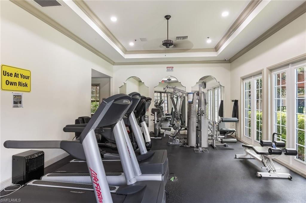 Community fitness center featuring multiple treadmills, strength training equipment, rubber flooring, and French doors
