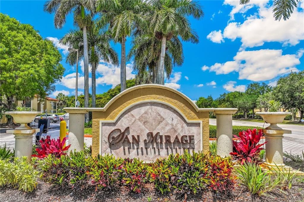 Ornate community entrance sign with decorative planters