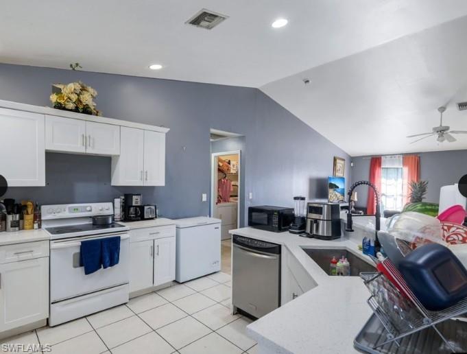 Kitchen featuring white cabinetry, light-toned countertops, tile flooring, stainless steel dishwasher, and a black gooseneck faucet