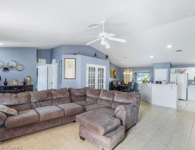 Open-concept living space featuring vaulted ceilings, tile flooring, recessed lighting, a ceiling fan, and French doors