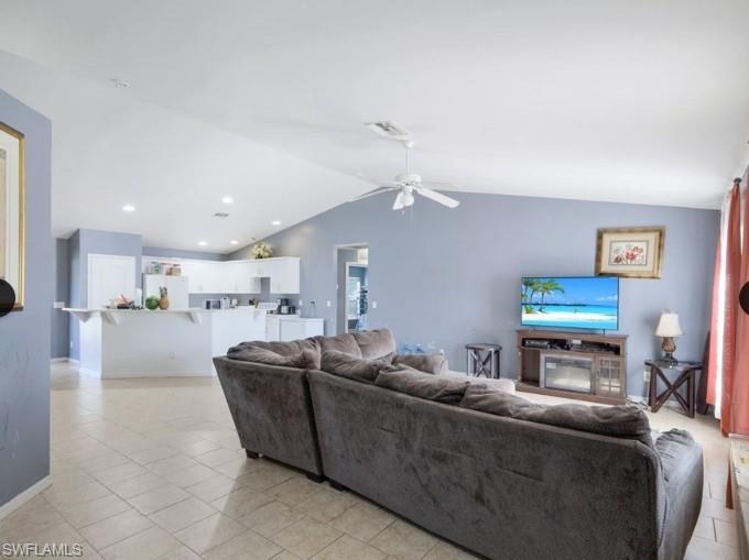Open-concept living area featuring a vaulted ceiling with a ceiling fan, recessed lighting, and tile flooring
