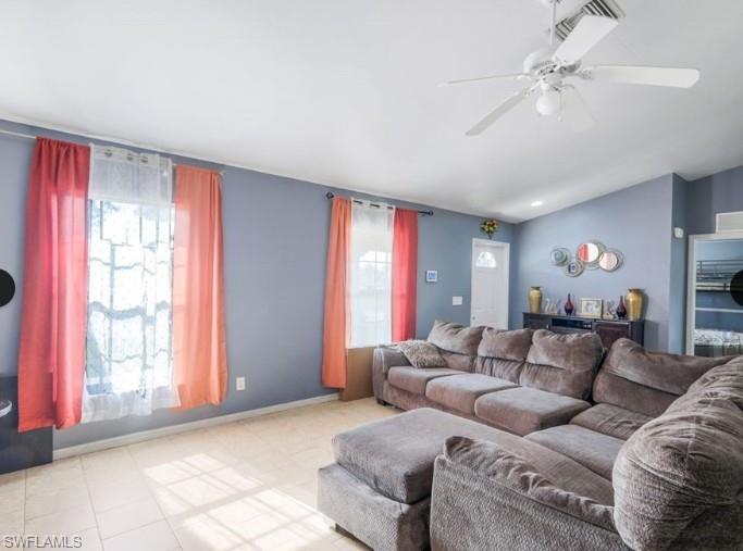 Vaulted ceiling with a white ceiling fan and integrated lighting