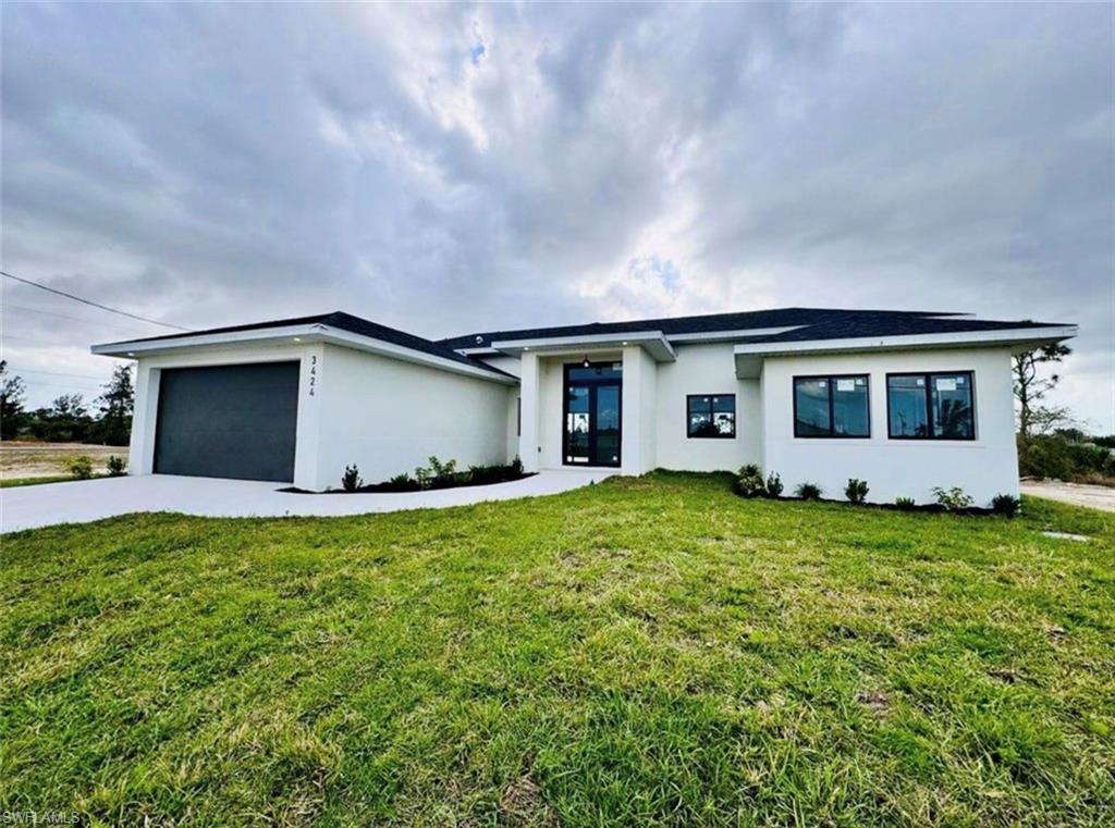 Contemporary single-story residence featuring a white stucco exterior and black framed windows