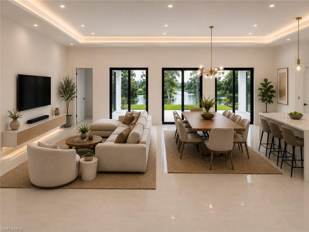 Spacious open-concept living area featuring light tile flooring, recessed lighting, and a tray ceiling with integrated lighting