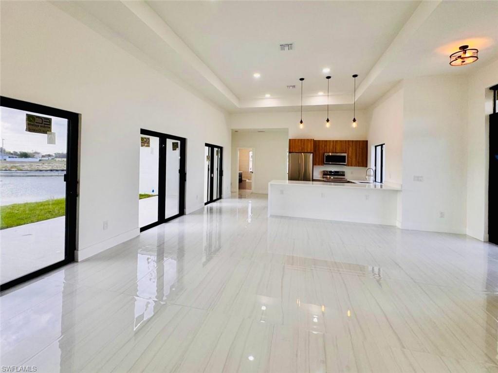 Spacious open-concept interior with large format white tile flooring throughout