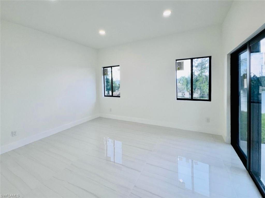 Spacious room featuring large format tile flooring, white baseboards, and recessed lighting